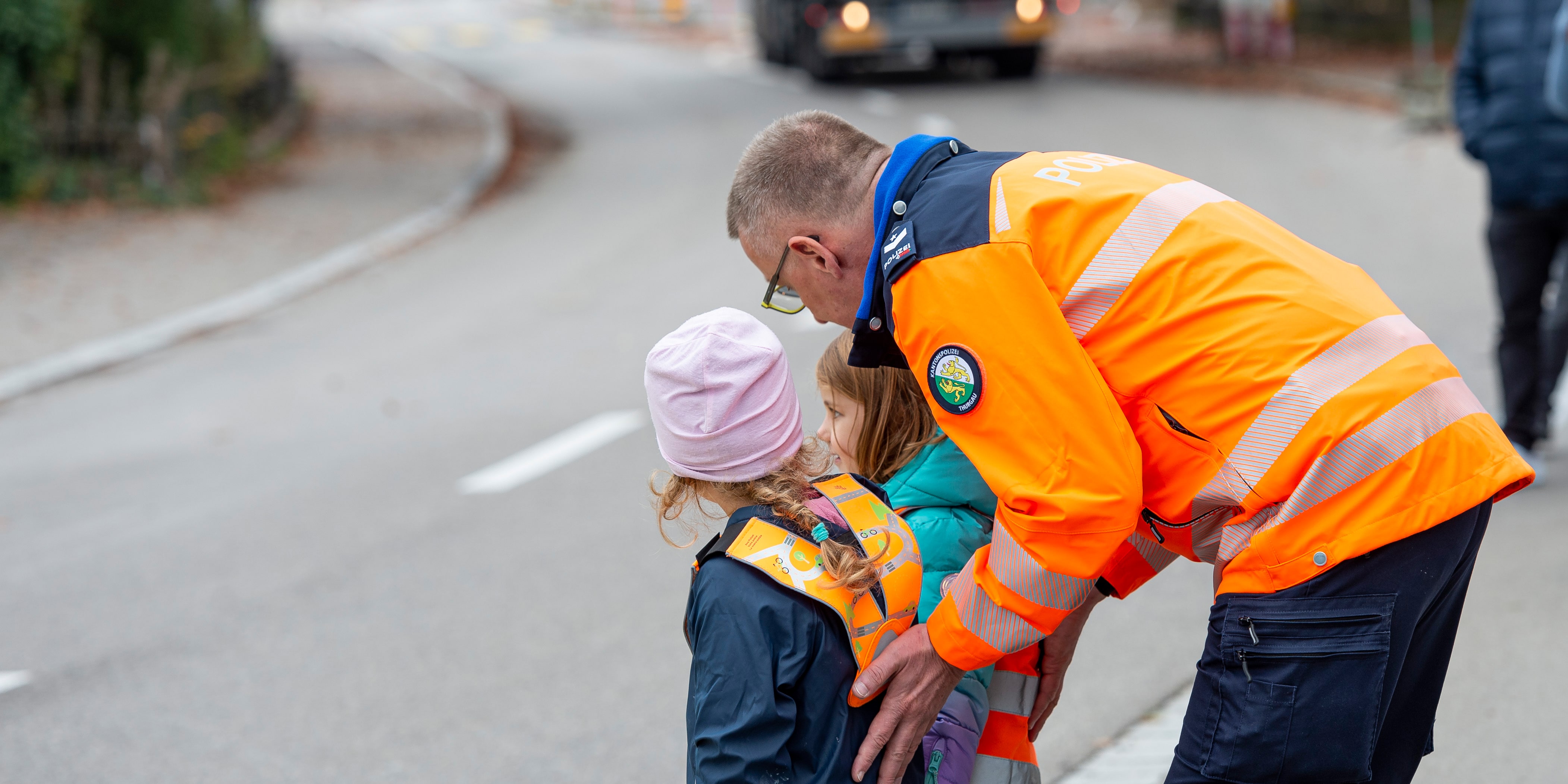 Bild Verkehrsinstruktor mit Kindergärtnern am Fussgängerstreifen