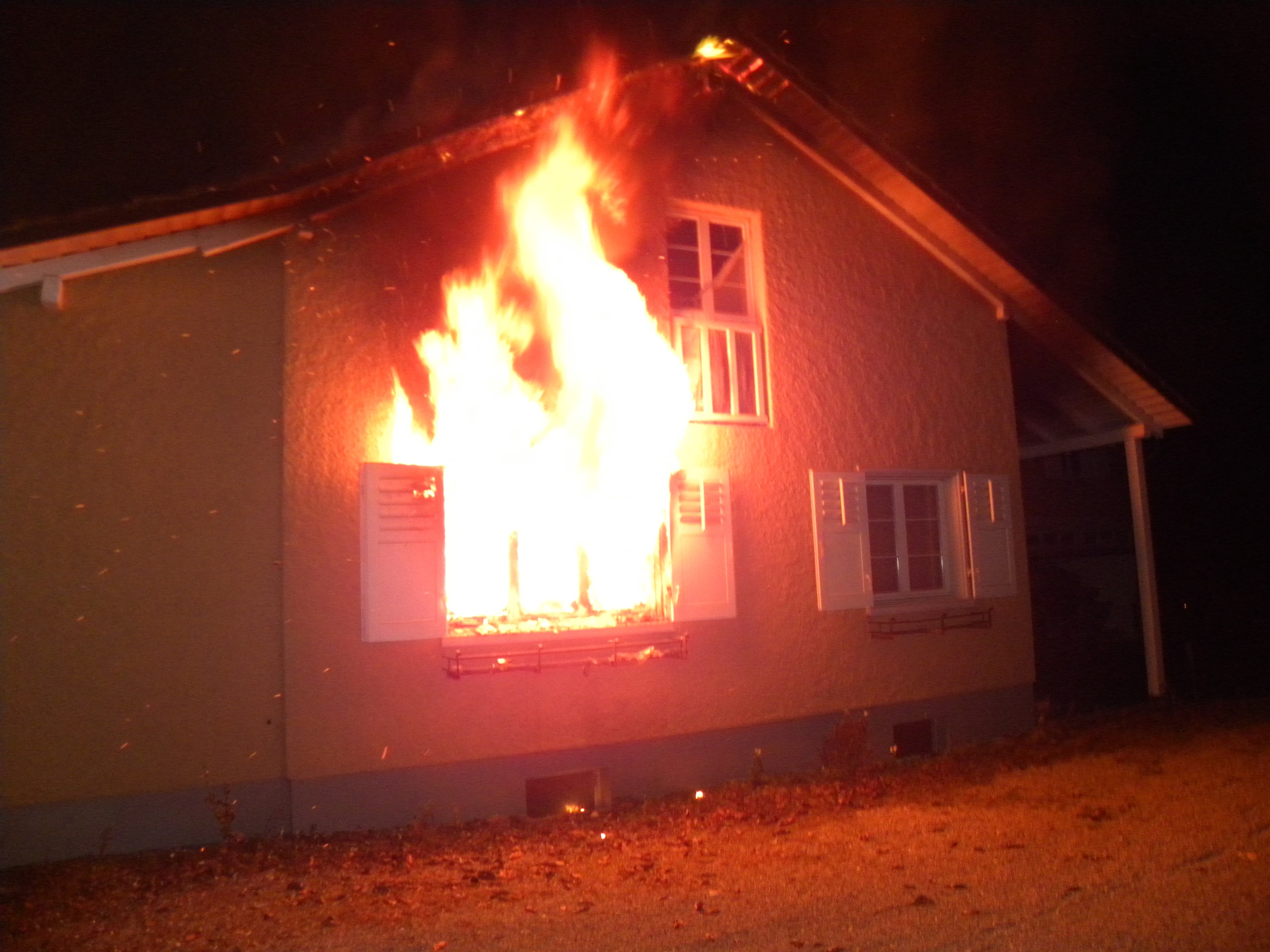 Haus in Brand, Flammen aus Fenster sichtbar